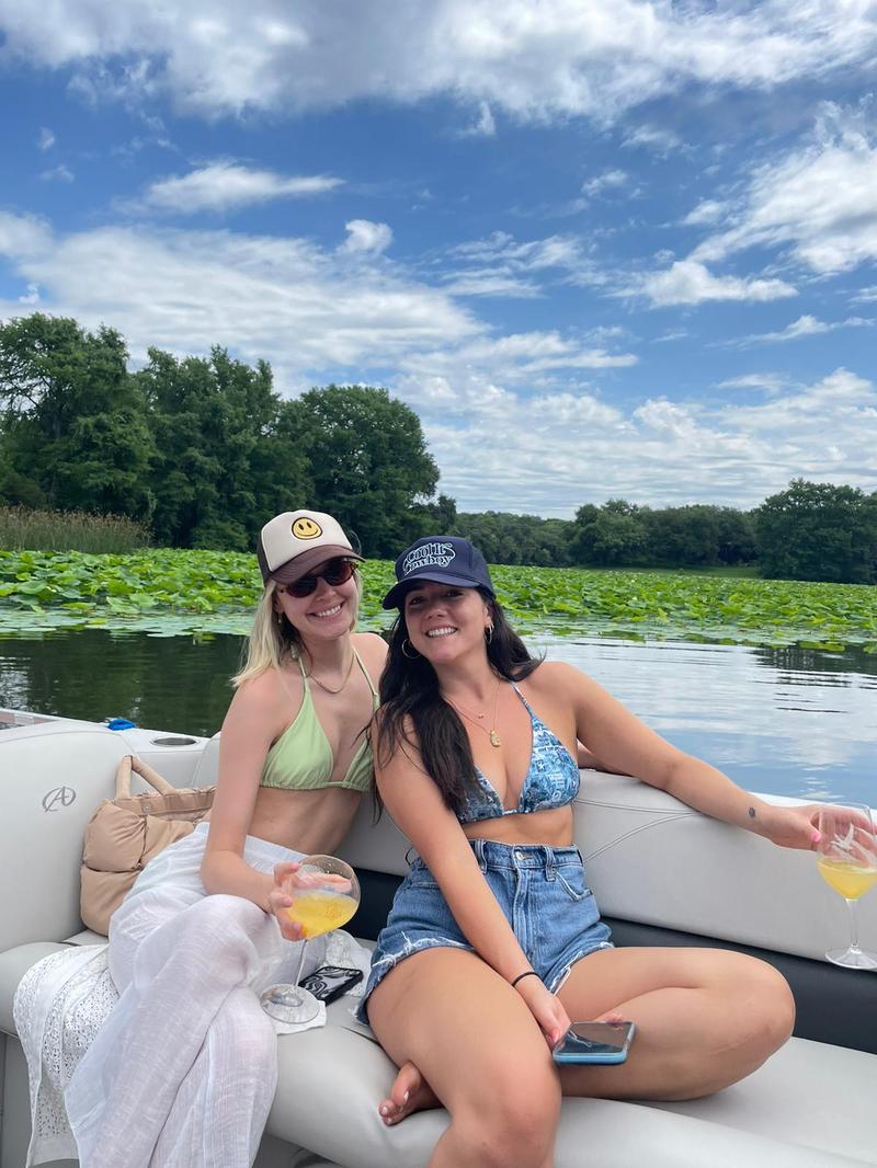 LakeTime guests relaxing on Lake Austin with mimosas on a sunny pontoon cruise