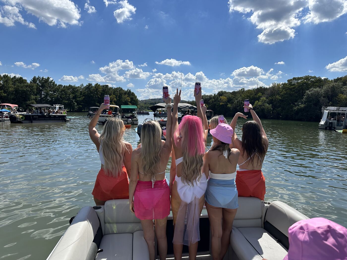 Bachelorette party raising drinks together on a LakeTime pontoon on Lake Austin