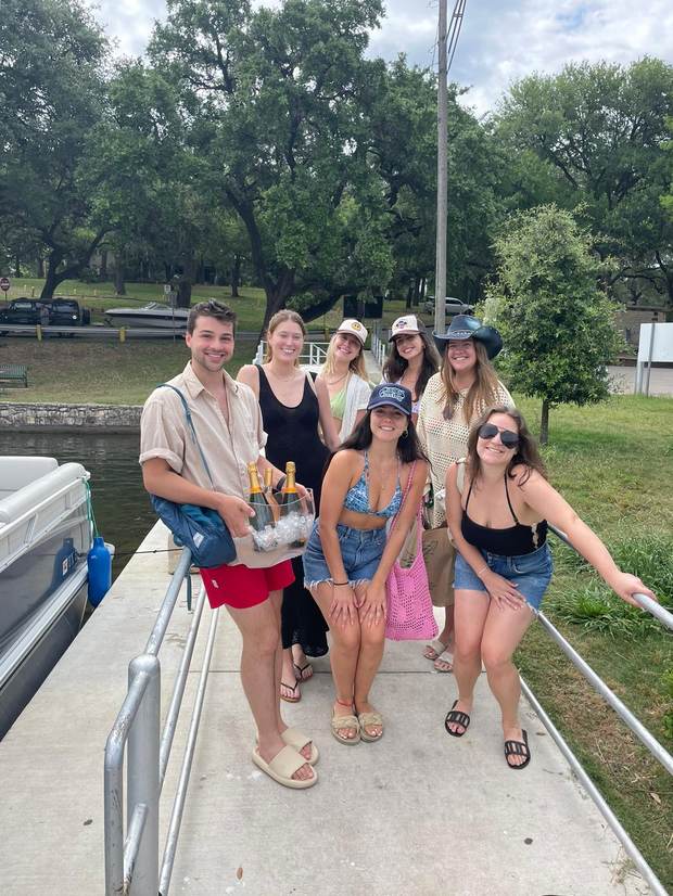 Friends celebrating on the dock before a LakeTime Lake Austin cruise