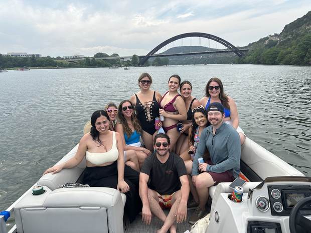 Large group celebrating together on a LakeTime pontoon near the 360 Bridge