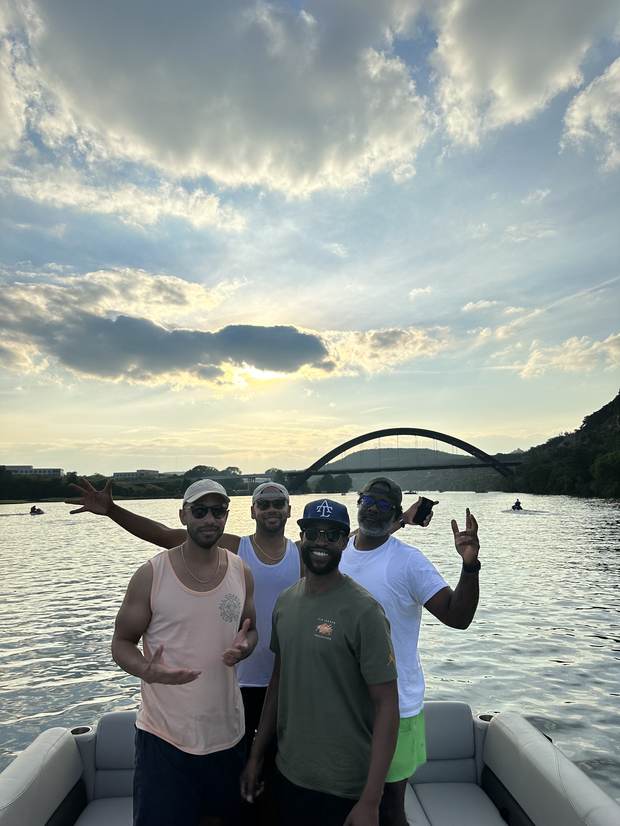 Friends enjoying a golden hour sunset cruise on Lake Austin