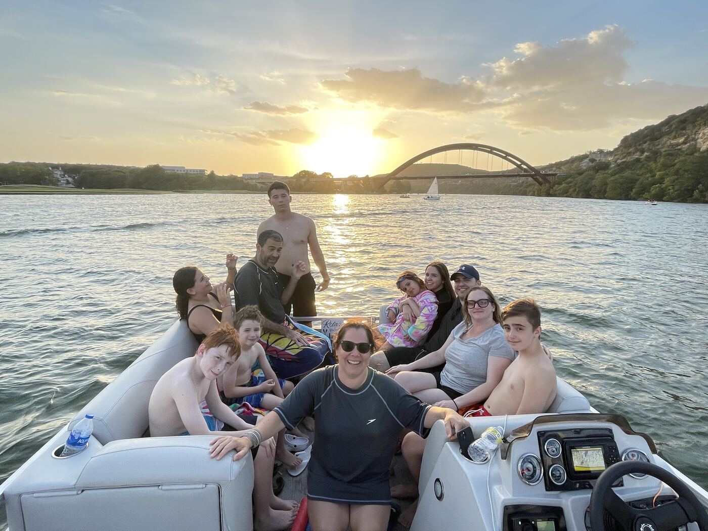 Large group photo aboard a LakeTime pontoon with the 360 Bridge in the background