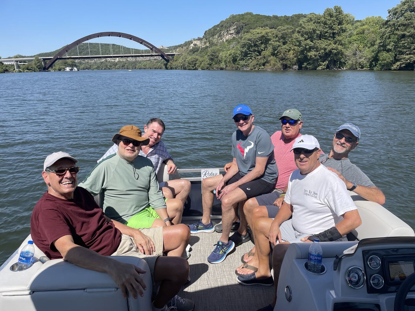 Group of friends floating together on Lake Austin with drinks in hand