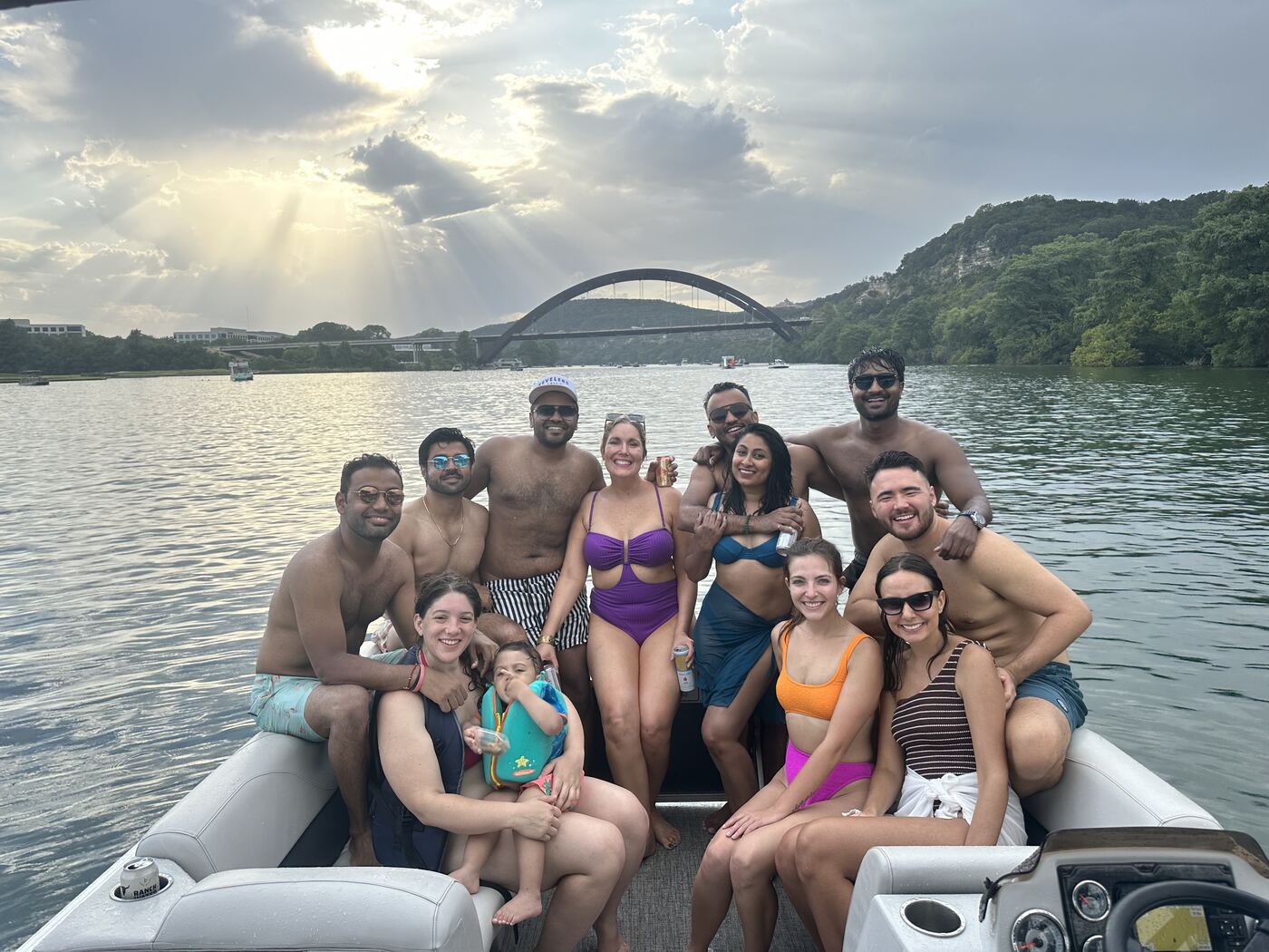 Golden hour group photo aboard a LakeTime pontoon near the 360 Bridge